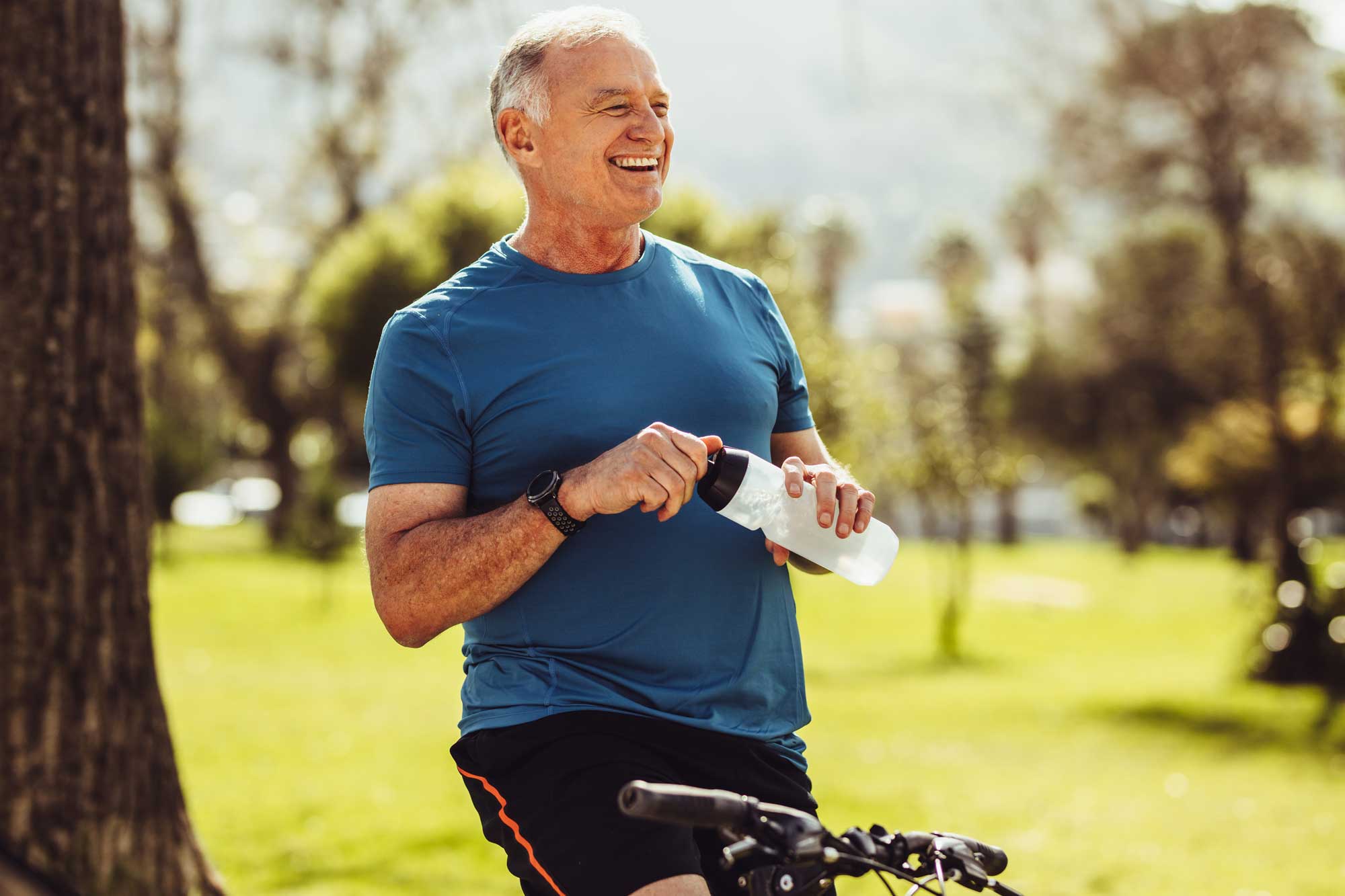 Older man showing a healthy lifestyle, sitting on his bike, smiling
