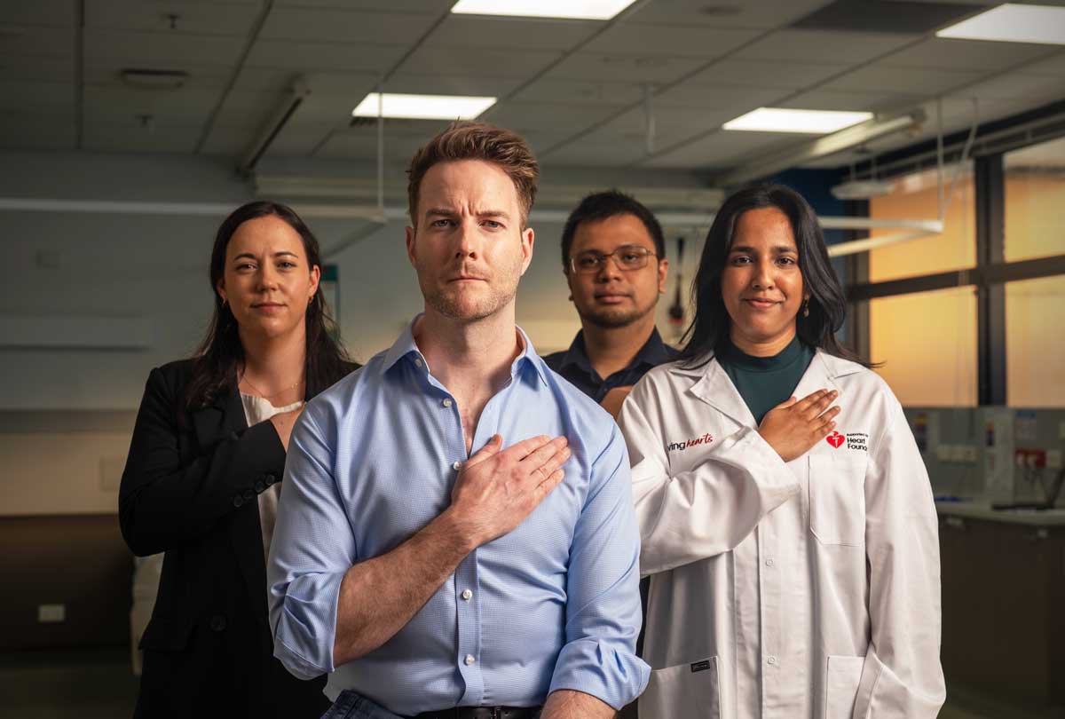 A group of Heart Foundation funded researchers with their hands over their hearts