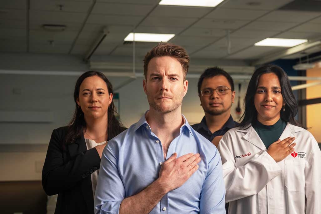 A group of Heart Foundation funded researchers with their hands over their hearts