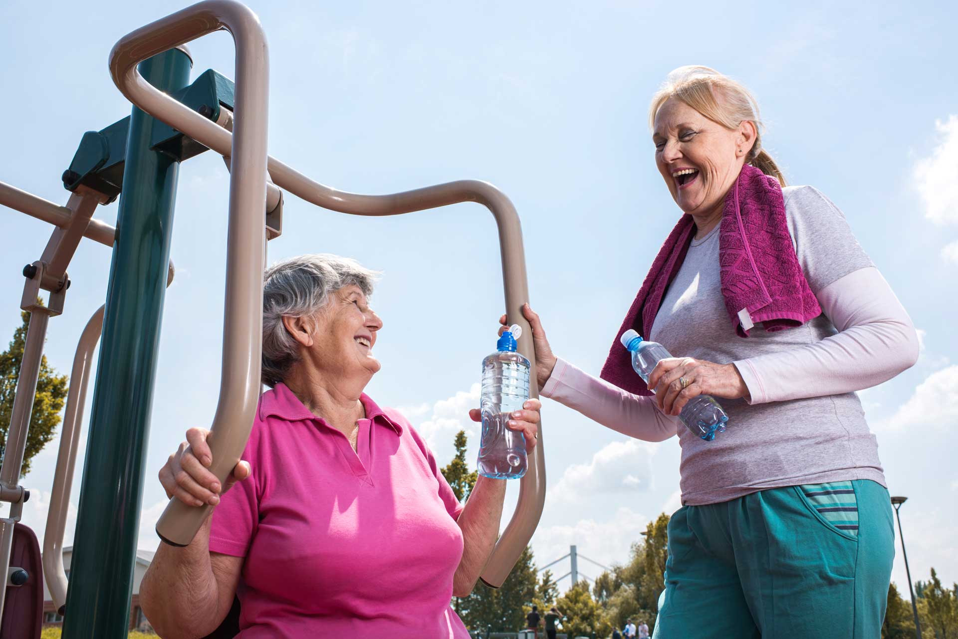 Two mature women exercising together outdoors