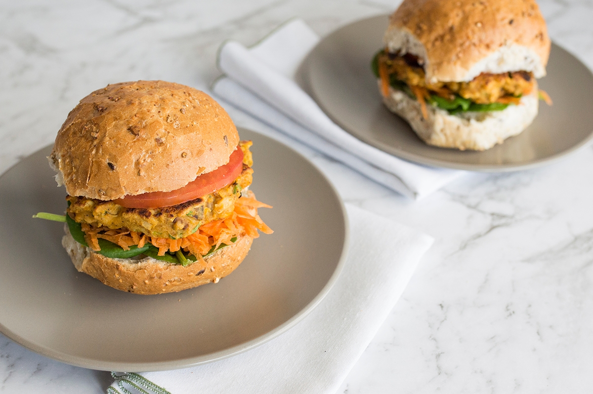 Two delicious hamburgers on plates, accompanied by a napkin