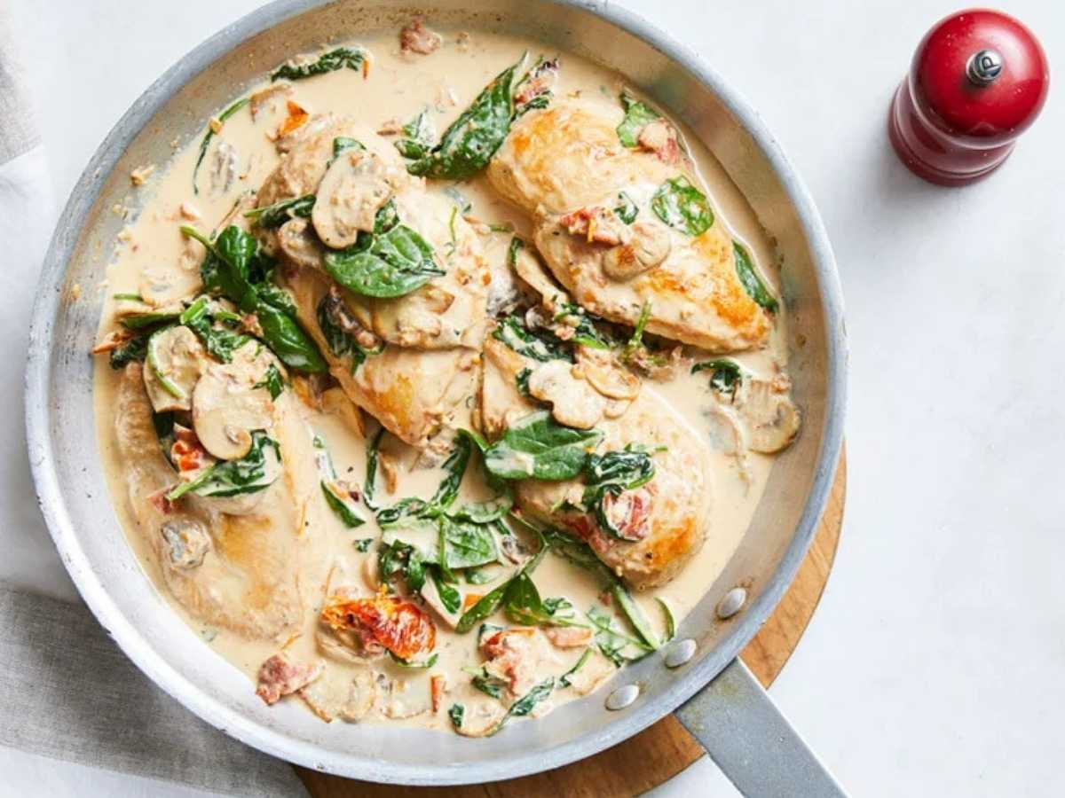 Creamy Tuscan chicken in a pan with vegetables