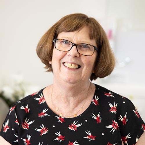 Jenny Doust wearing glasses and a floral shirt.