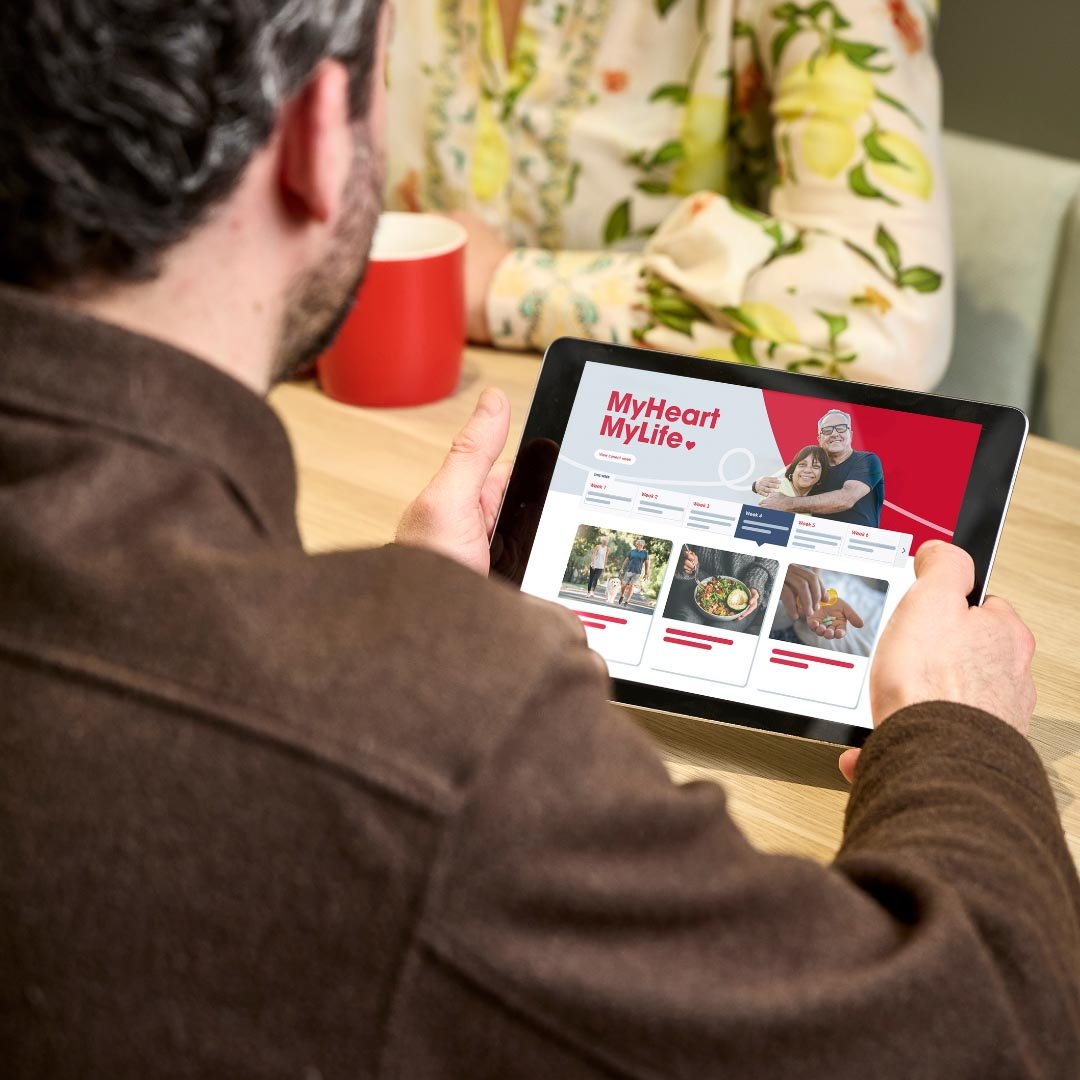 View over man's shoulder looking at MyHeart MyLife on tablet