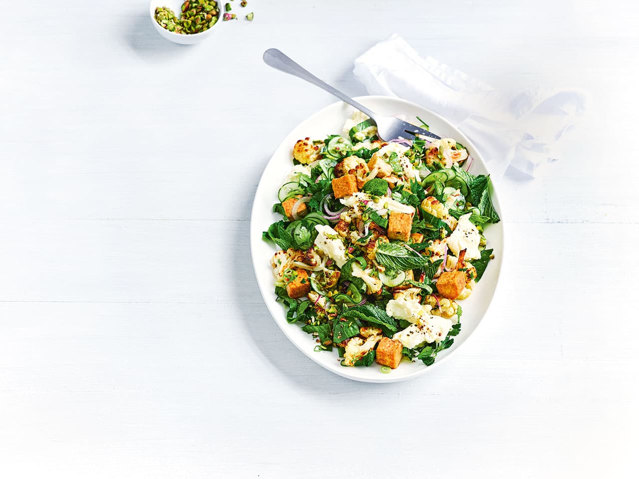 A delicious bowl of Roasted Cauliflower Tempeh Salad on a table