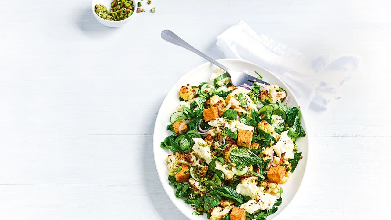 A delicious bowl of Roasted Cauliflower Tempeh Salad on a table