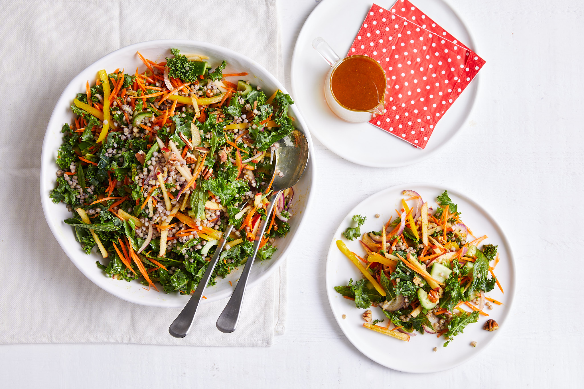 A white table displaying two bowls of salad
