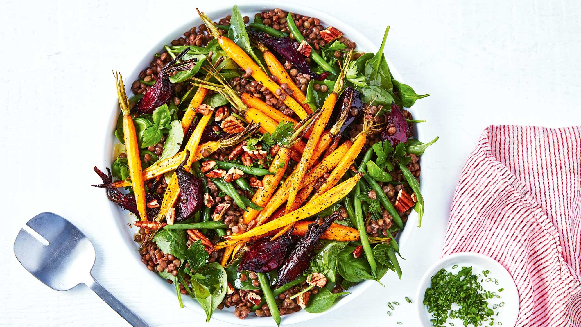 A vibrant salad featuring crisp greens, colourful carrots and beetroot in a visually appealing dish
