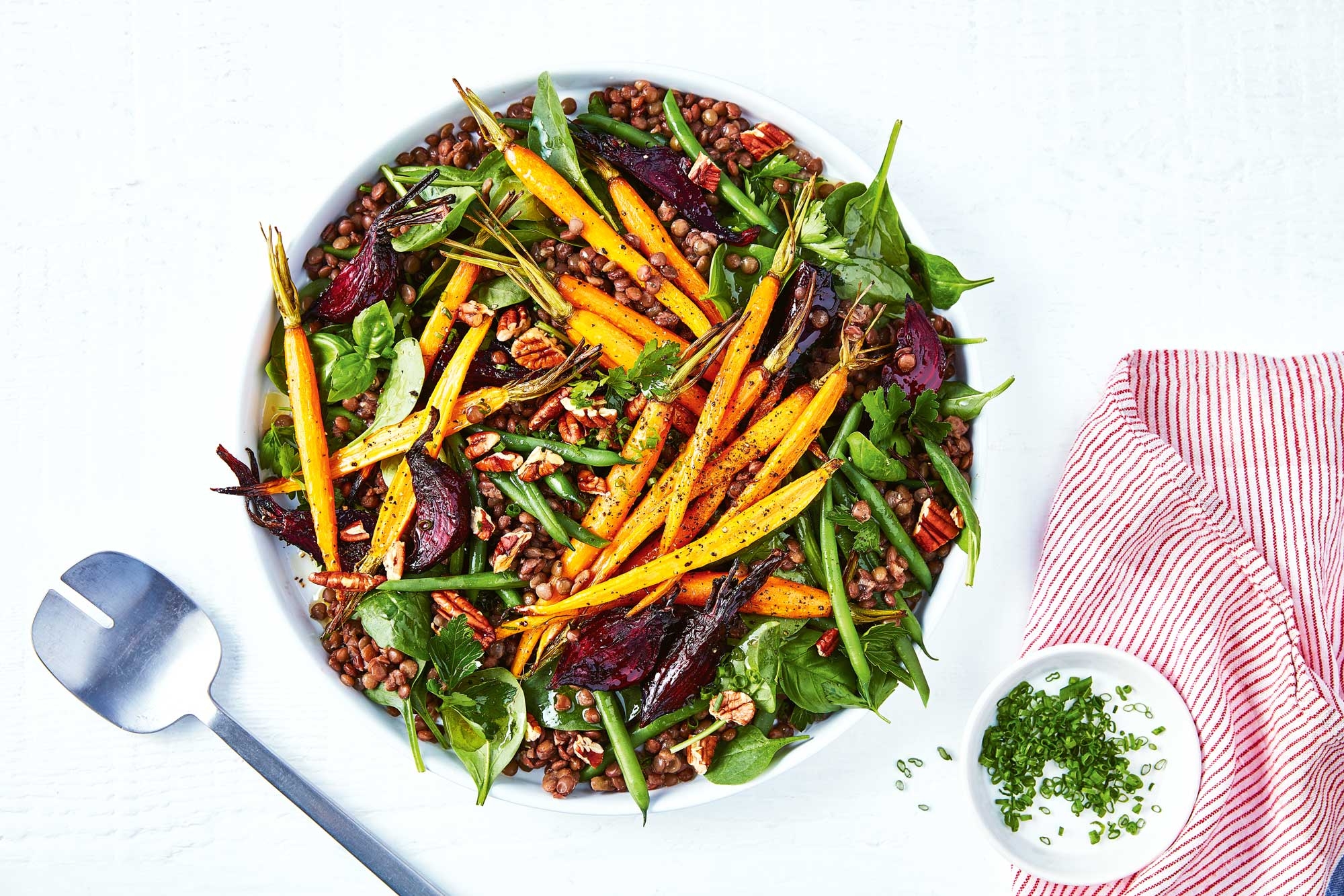 A vibrant salad featuring crisp greens, colourful carrots and beetroot in a visually appealing dish