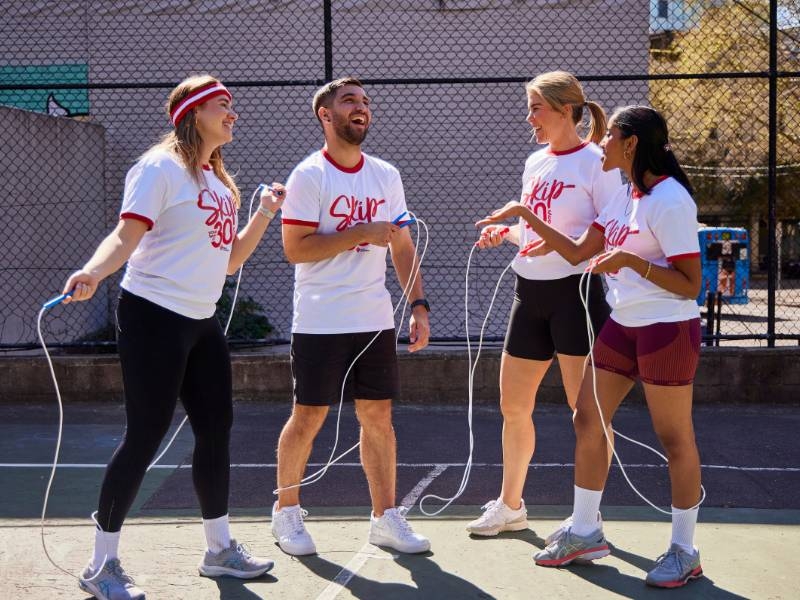 A group of young adults standing around with skipping ropes, wearing 'Skip Your Way' t-shirts