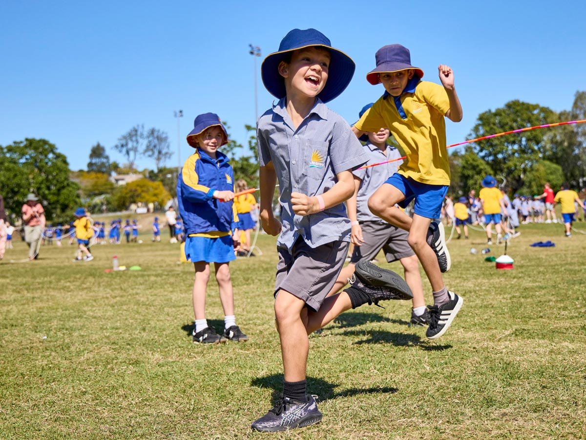 Primary school kids jumping over a skipping rope outside
