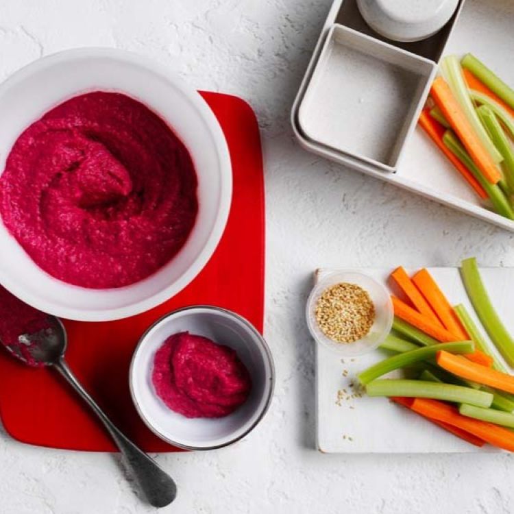 Beetroot dip topped with sesame seeds and served with vegetable sticks
