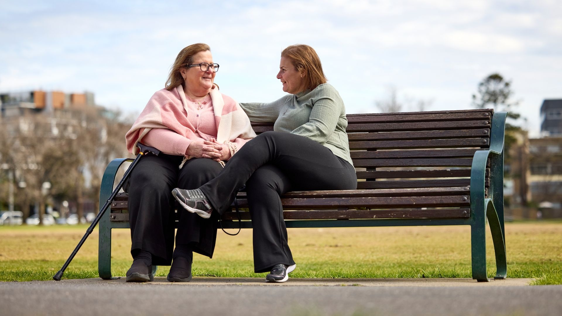 Two Arabic women speaking on a park bench