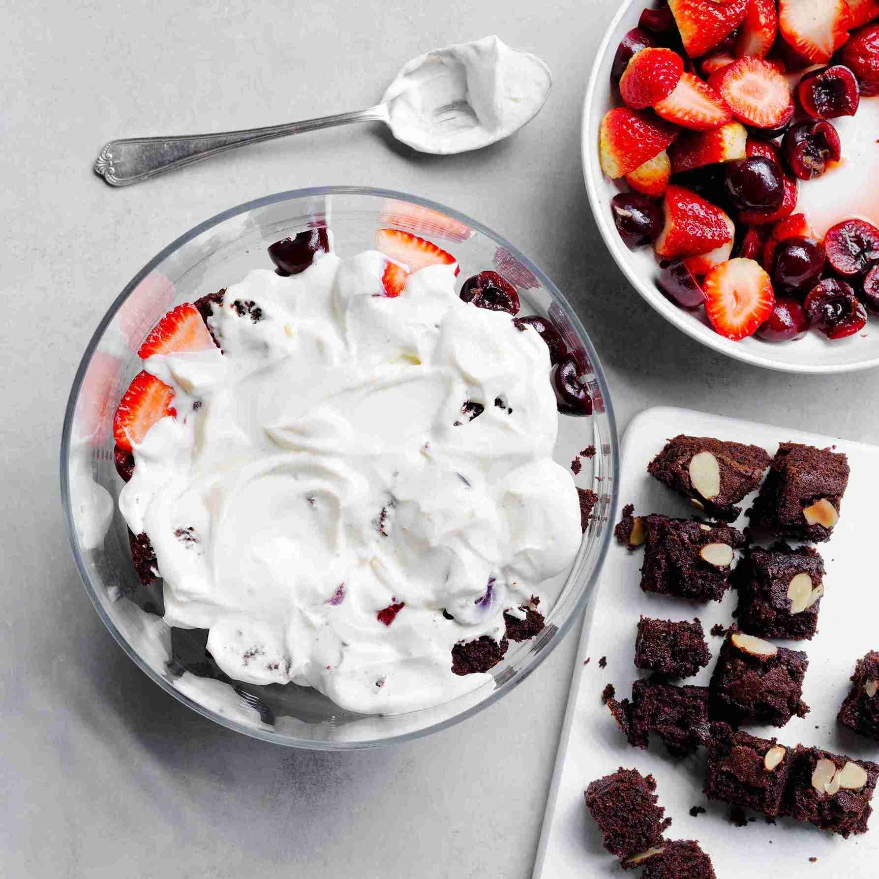 layered dessert in a glass bowl with cake, fruit, and ricotta mixture