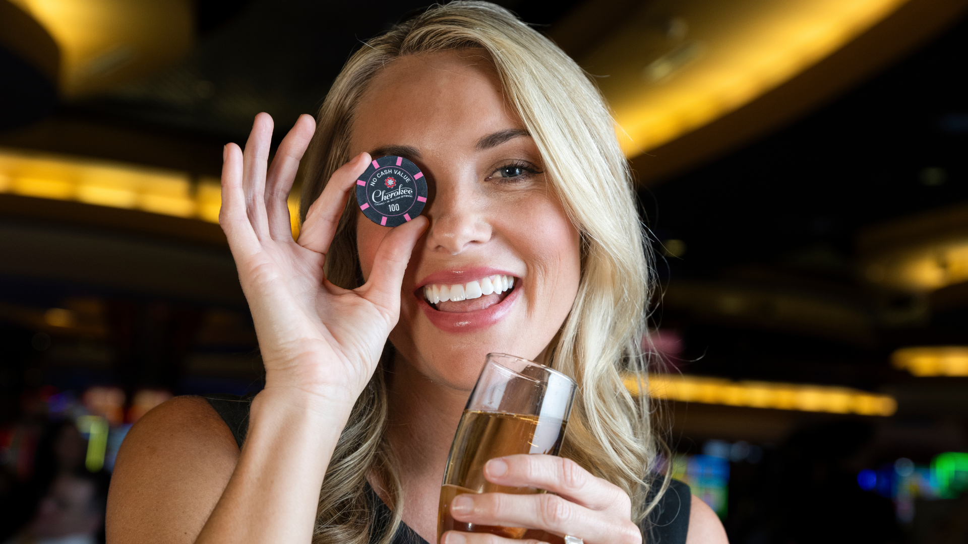 Girl holding poker chip over her eye