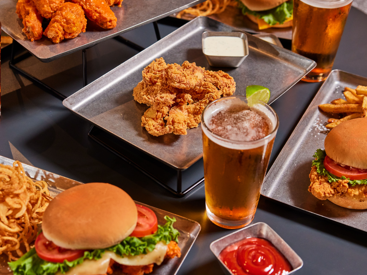 Picture of chicken fingers, beer, and a cheeseburger