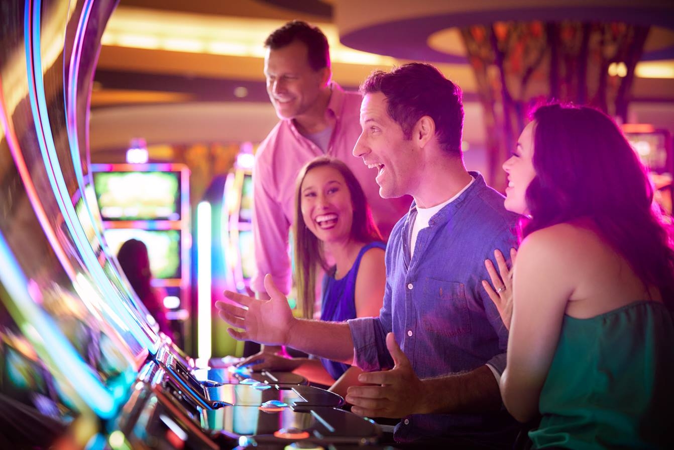 People laughing and playing on slot machines