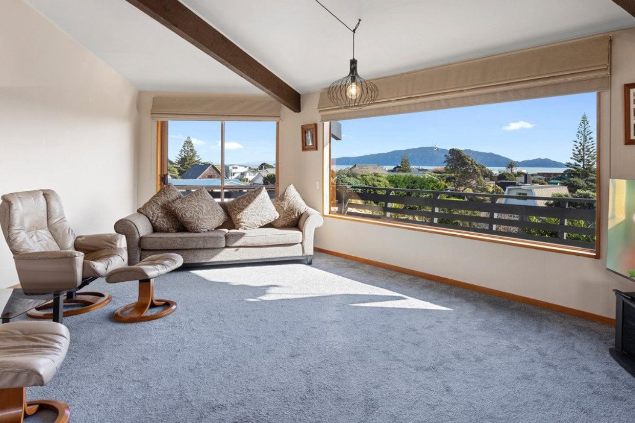 Large windows capturing the mountain range and ocean views. 