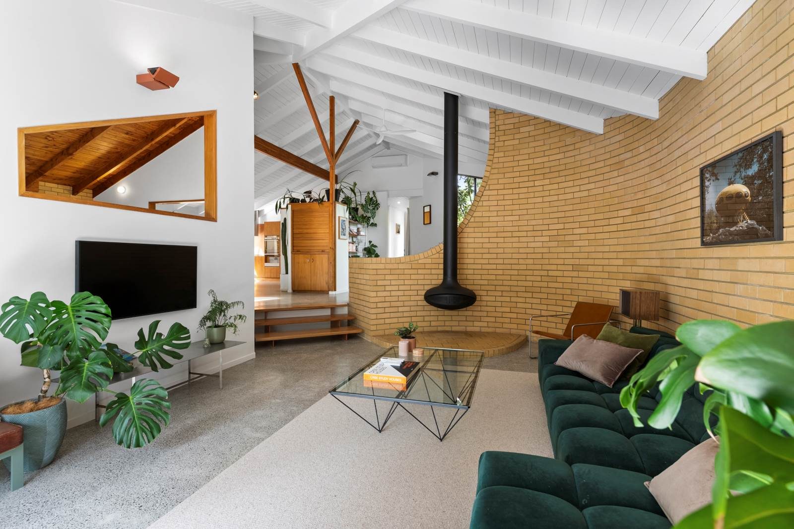 A curved internal brick wall with fireplace.