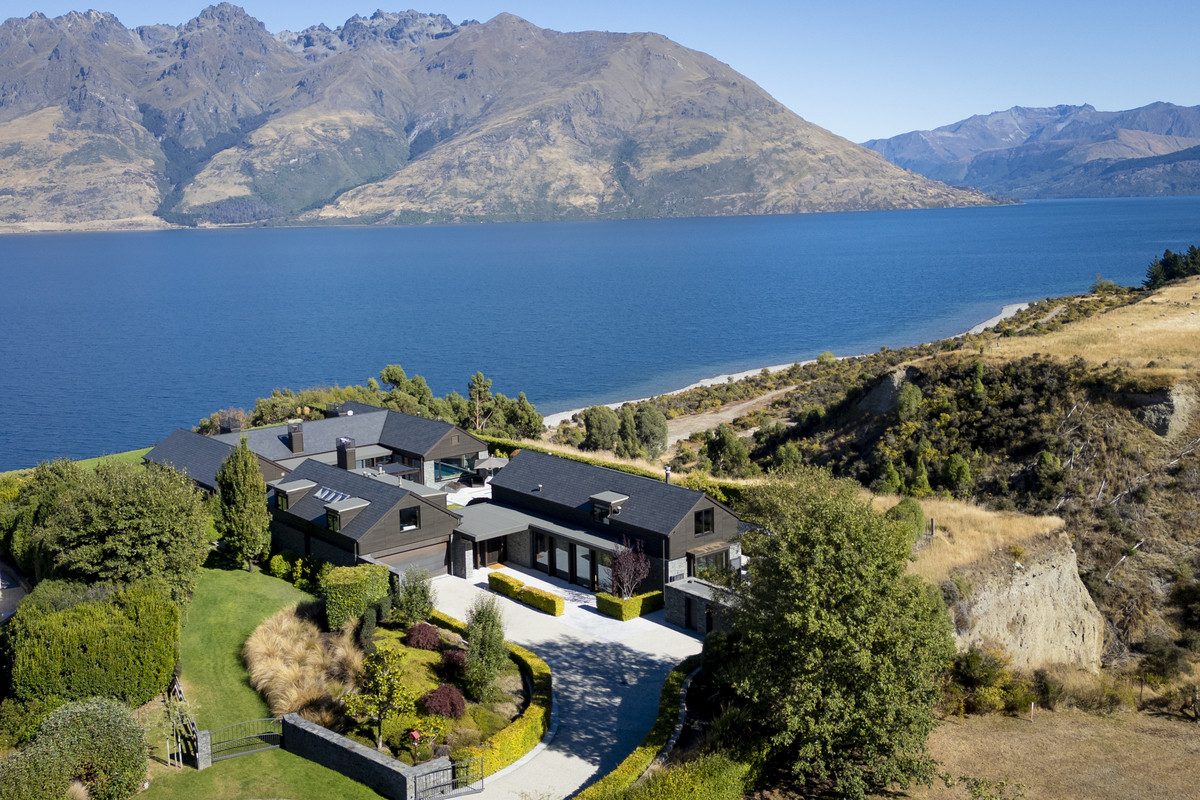 Aerial view of a large dark-clad estate overlooking lake and mountains at 10 Bluff View Terrace, Queenstown