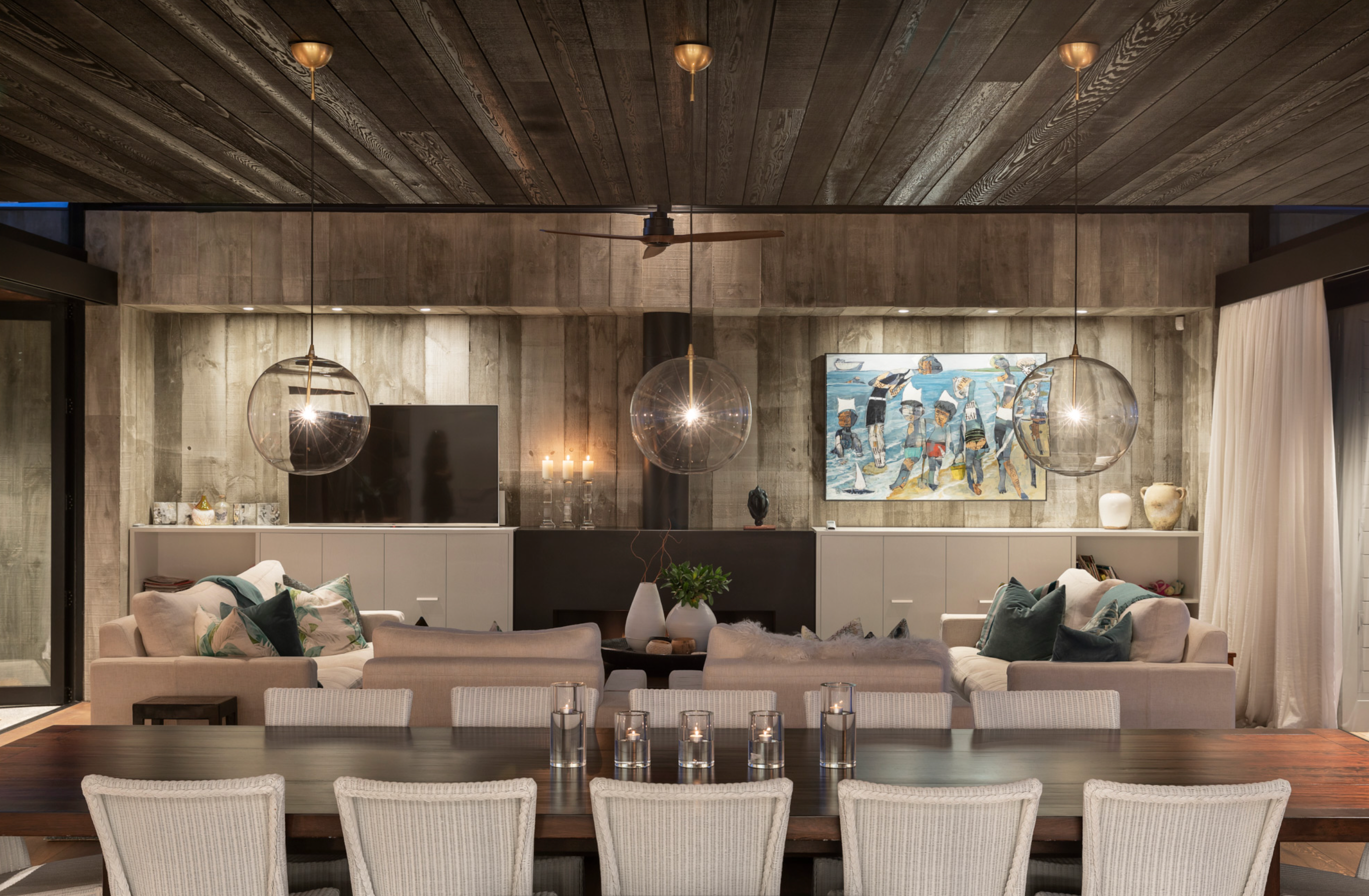 Traditional lounge in the 2021 City Home of the Year by CAAHT Studio, featuring oversized off-white Rosetti couches around a wide fireplace, balancing casual and formal vibes.