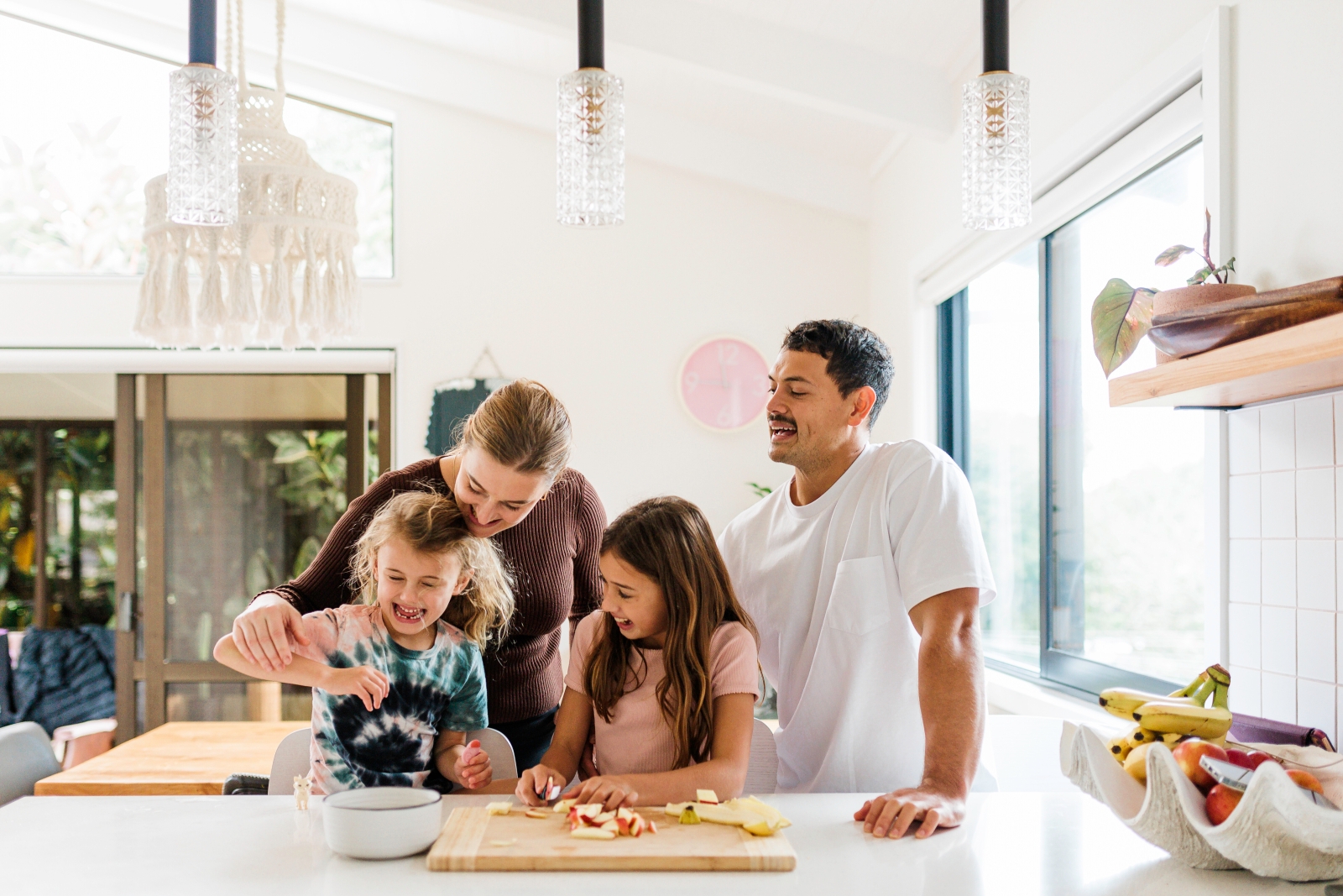 Family chopping fruit in kitchen