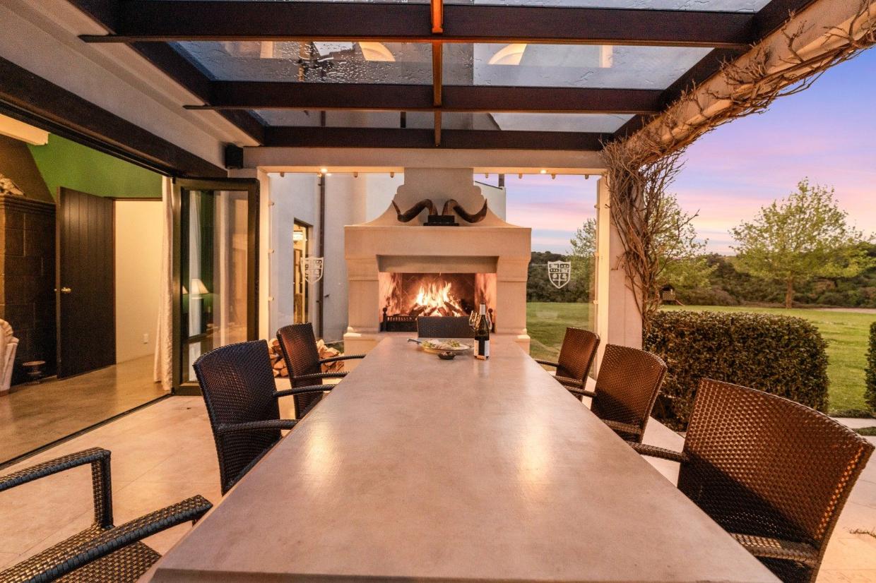 A covered alfresco seating area with fireplace 
