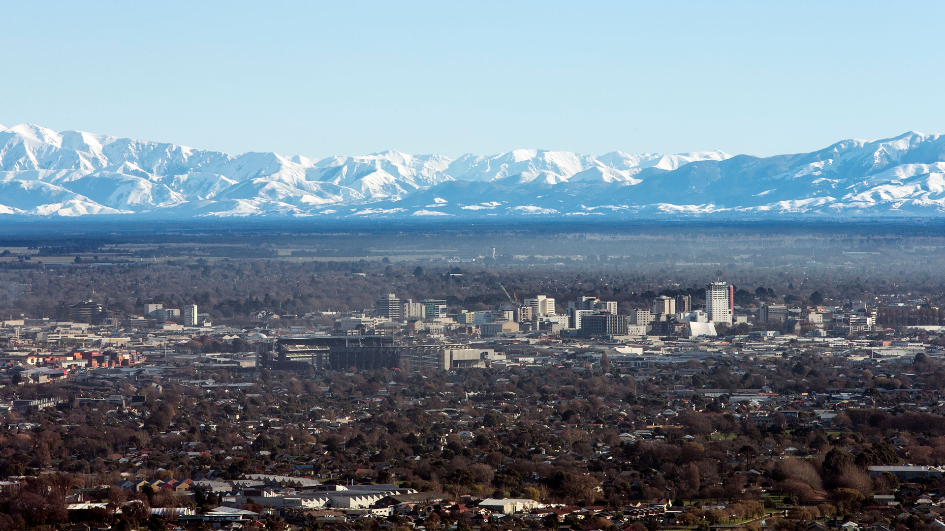 A photo of Christchurch city centre with snow-capped mountains in the background.