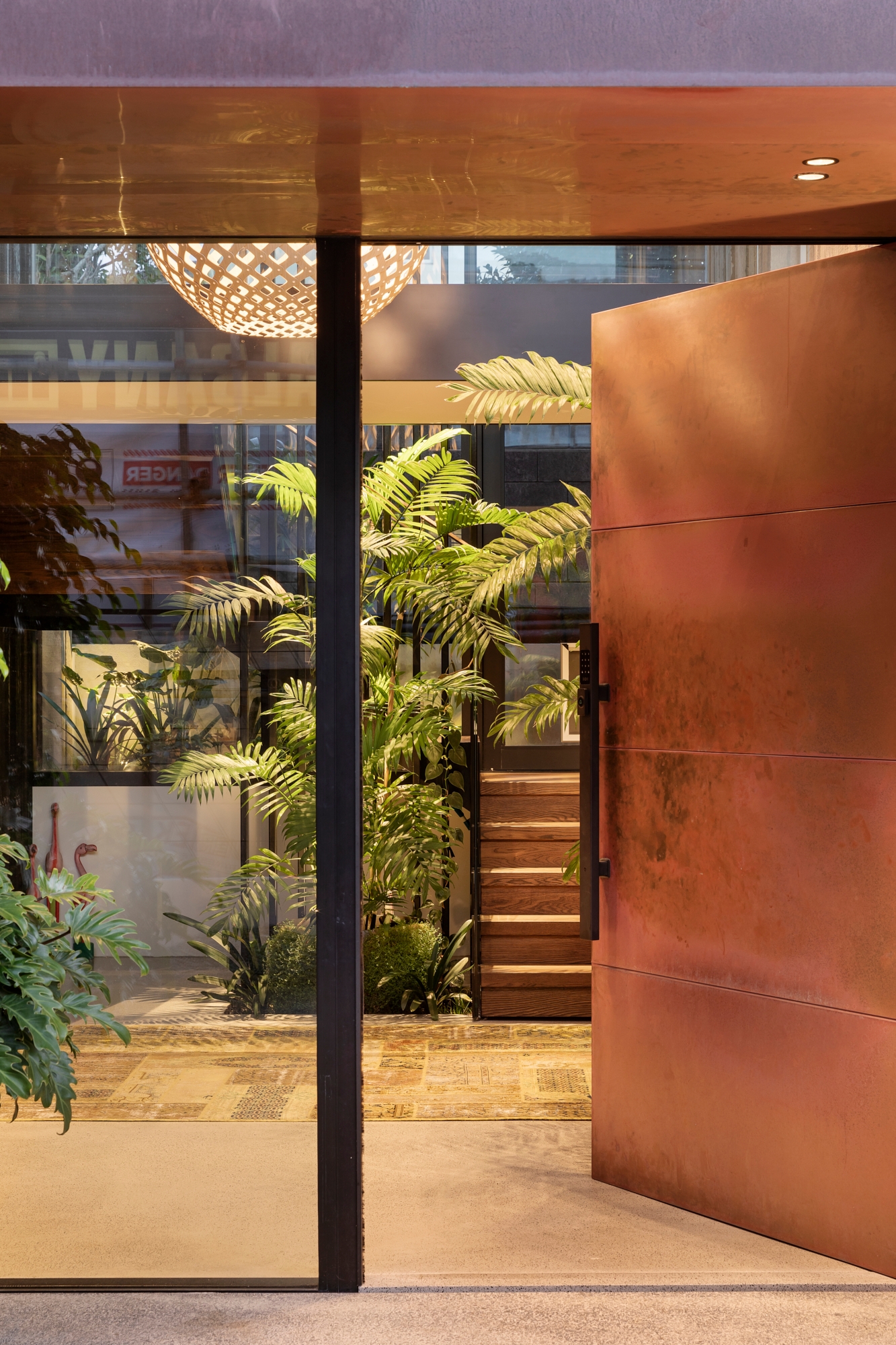 At the entrance to the 2021 City Home of the Year, House on Takapuna Beach by CAAHT Studio, the lightness of the yellow patchwork rug creates a refuge of privacy and nature and complements the materials and textures of the architectural elements. Image: Sam Hartnett