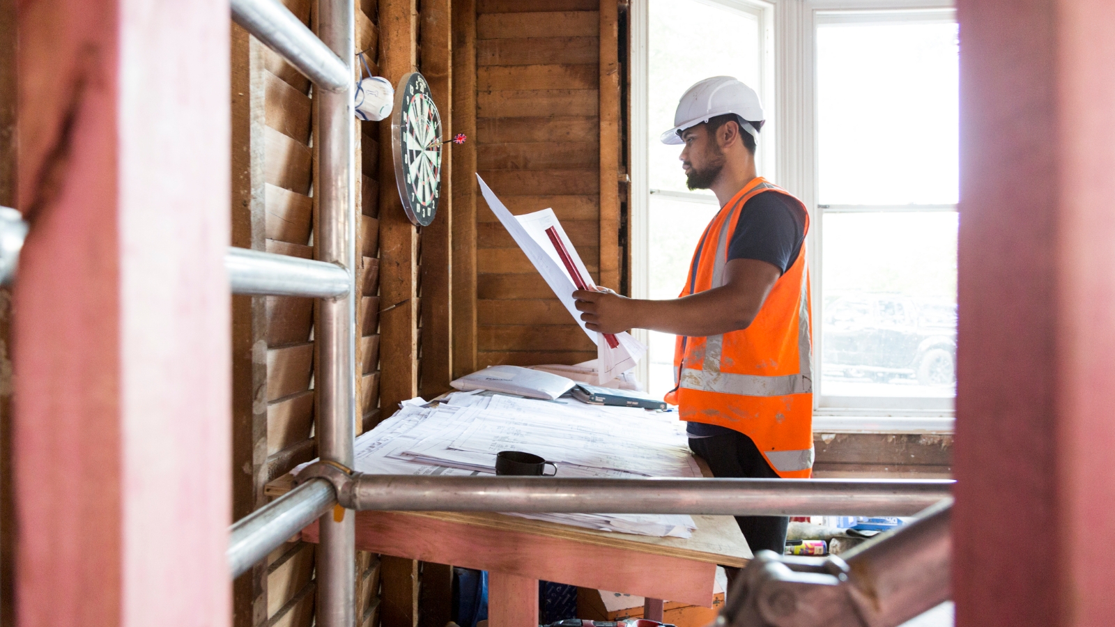 Builder on site looking at plans.