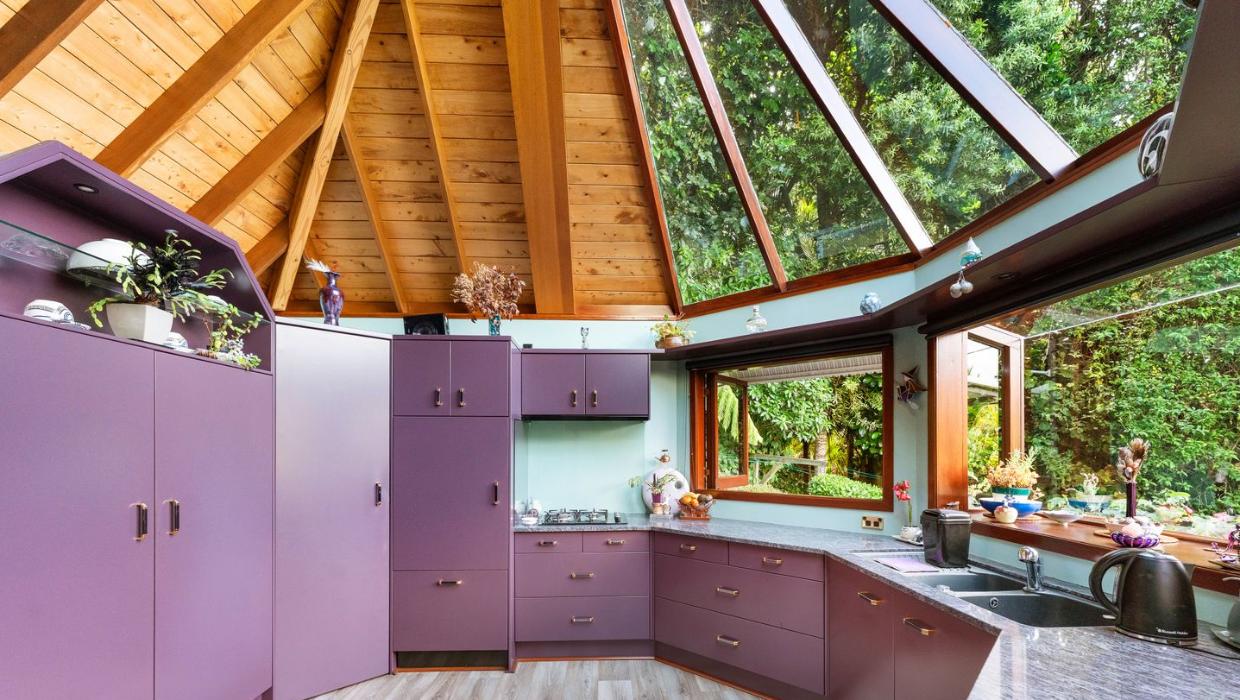 The kitchen interior is purple and has a glass and cedar roof.