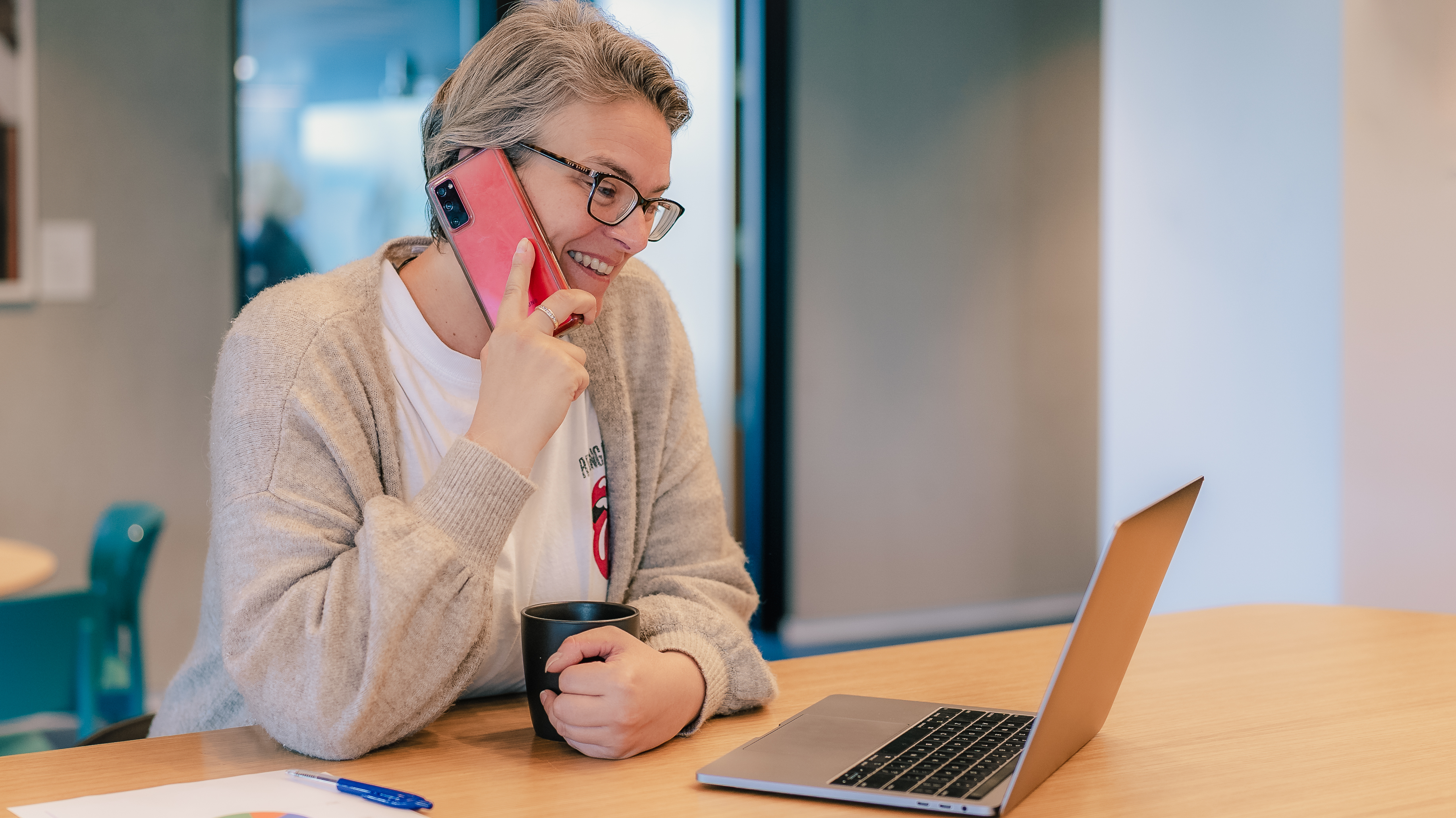 Smiling woman on the phone with laptop