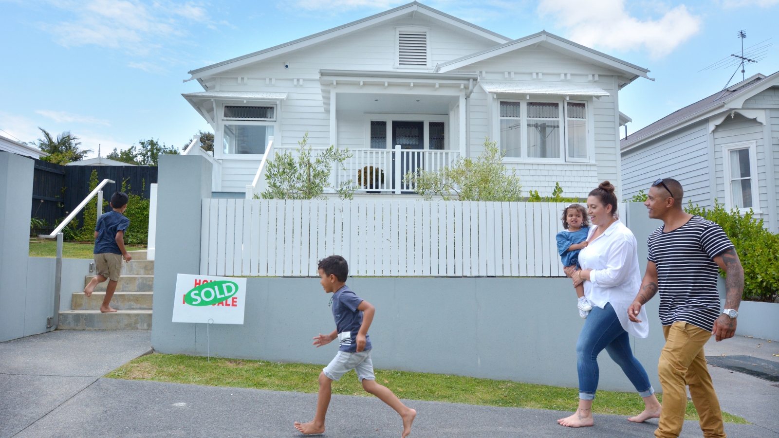 Family with two kids running into house. 