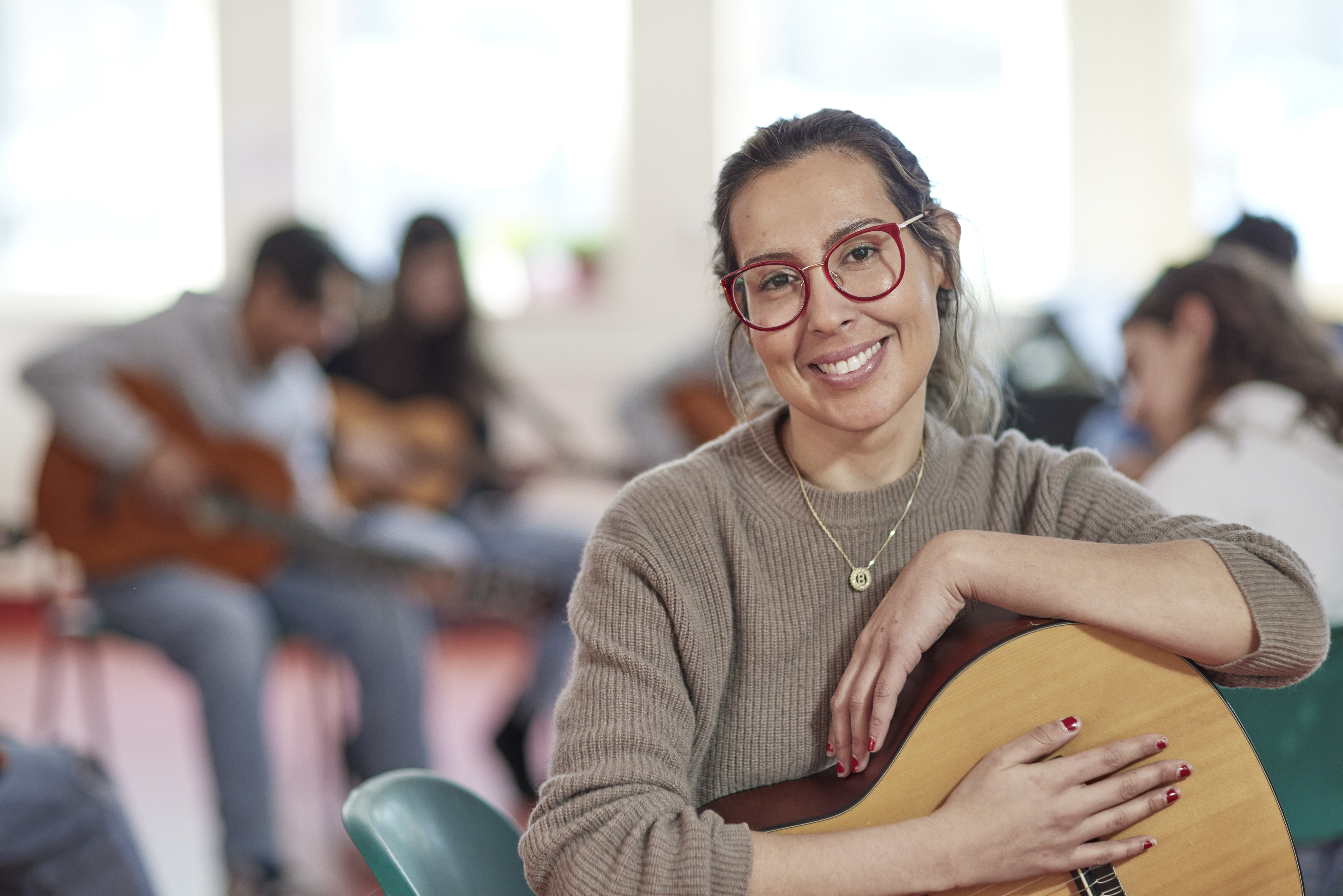 Female teacher sitting on chair with students in the background