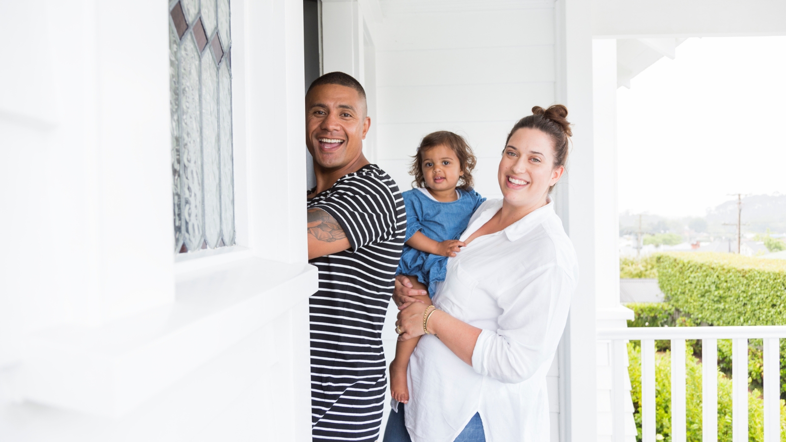 Family of three walking into first home. 