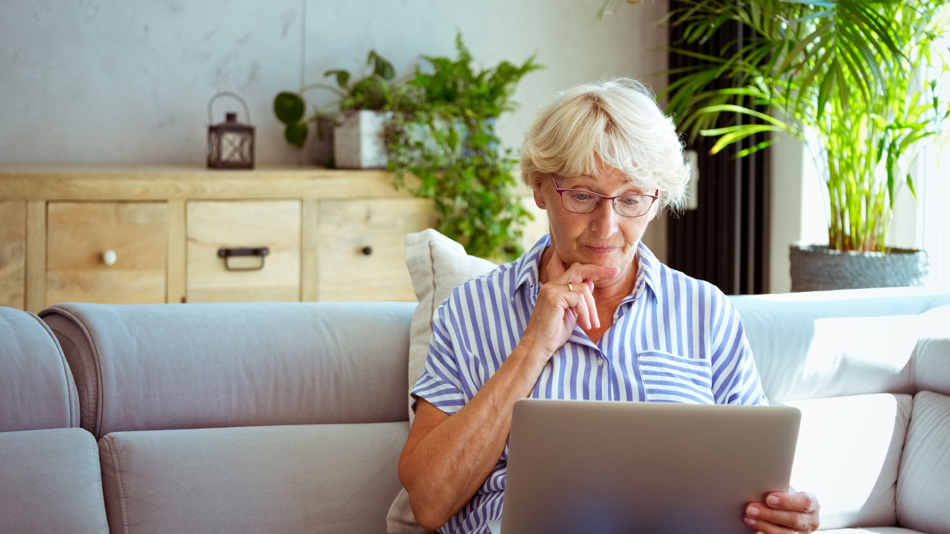 Landlord looking at market rates for rent on her laptop when considering rent increases.