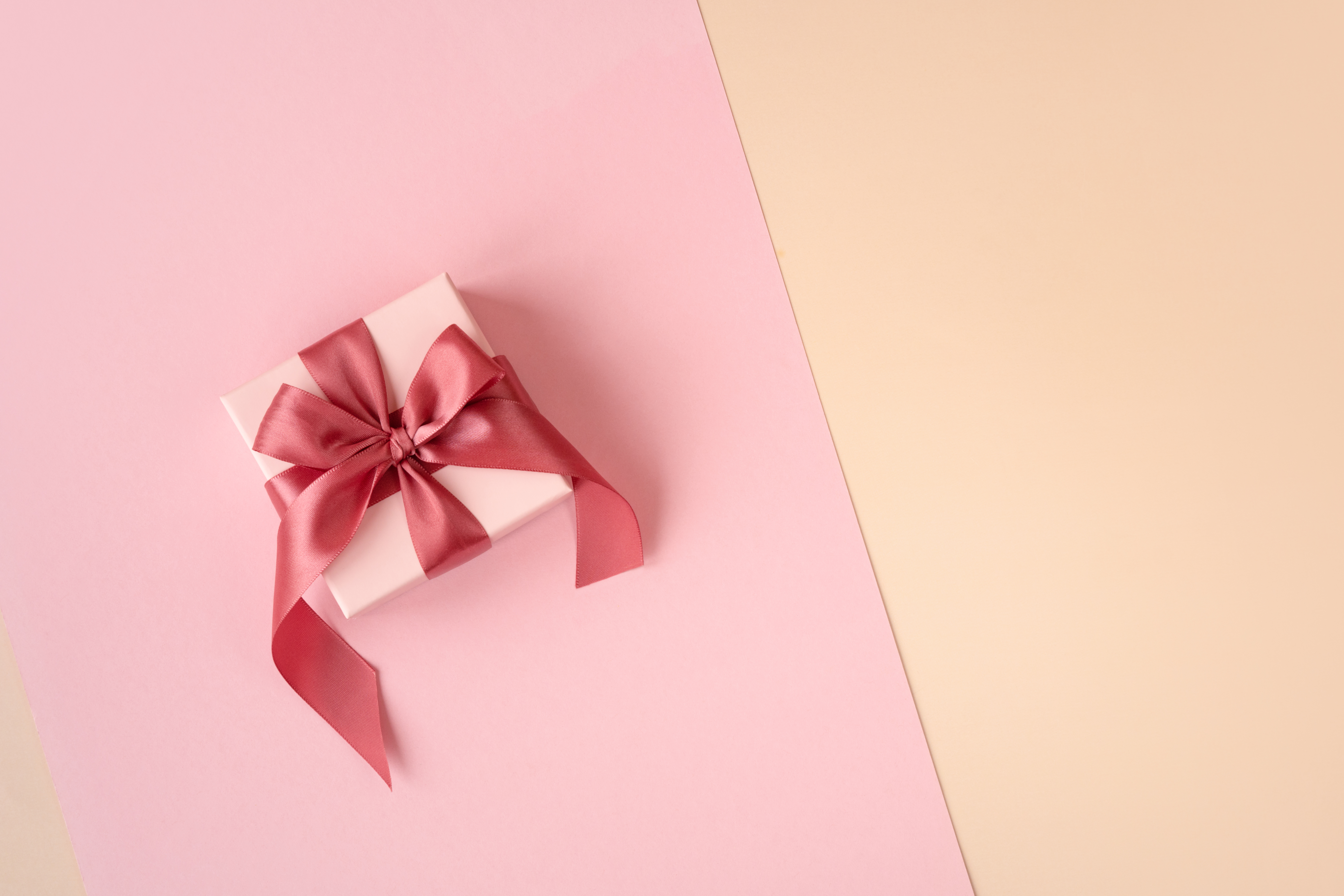 Top gift ideas for Mum. A pink gift box with red ribbon.