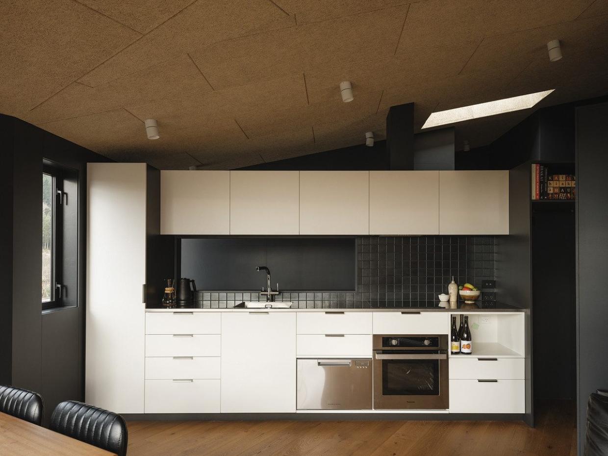 The kitchen interior design shown that has white cabinet doors and drawers that create a striking contrast to the black.