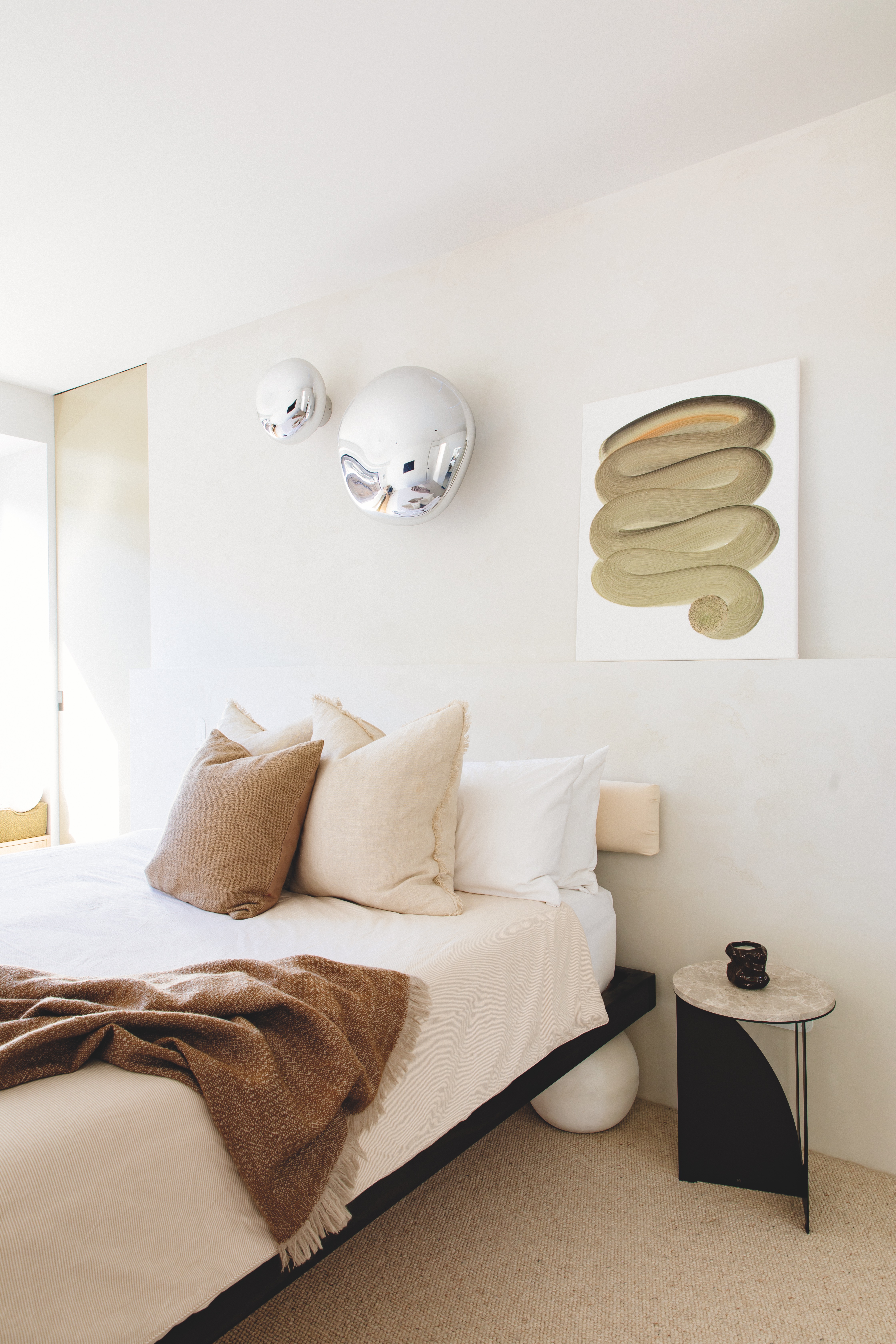  The couple are enjoying adding to their art collection. In the main bedroom, a piece by Dan takes pride of place beside a pair of Melt lights by Tom Dixon from ECC. The bed is another of Dan and Matt’s creations; they designed, stained and upholstered it, and had concrete balls crafted for its legs. It’s teamed with an Arch side table by Made of Tomorrow that has a Tundra Grey stone top.