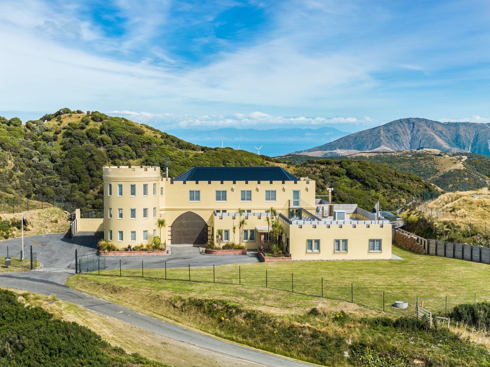 A yellow castle sits on the hilltop of Wellington complete with its own turret. 