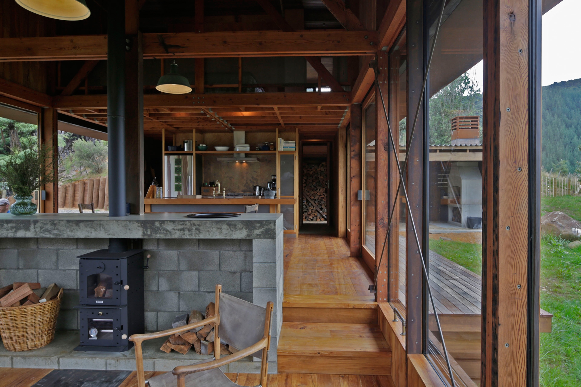 Long view of the living room and kitchen surrounded by natural materials