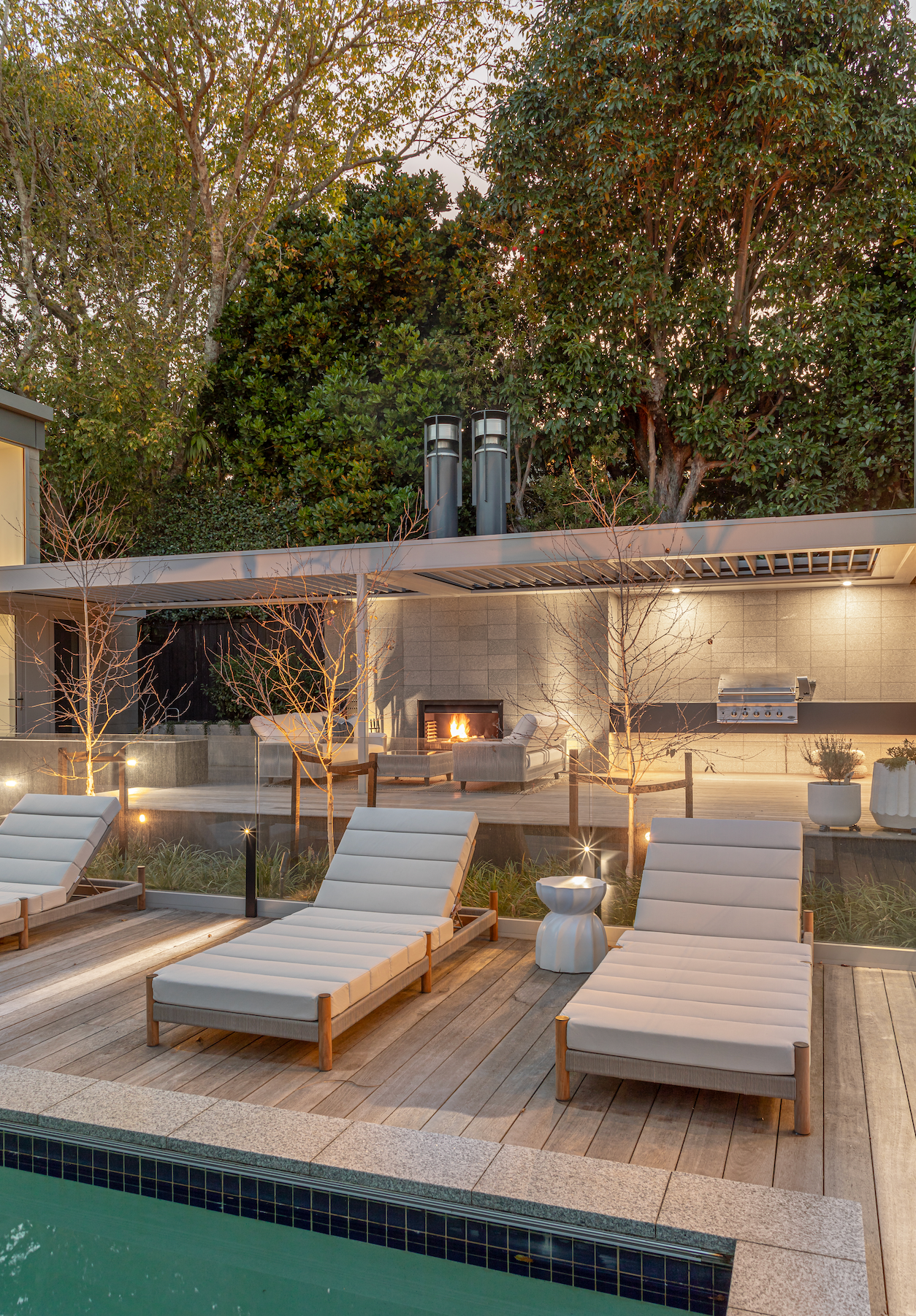 Cushioned deck chairs in front of a pool