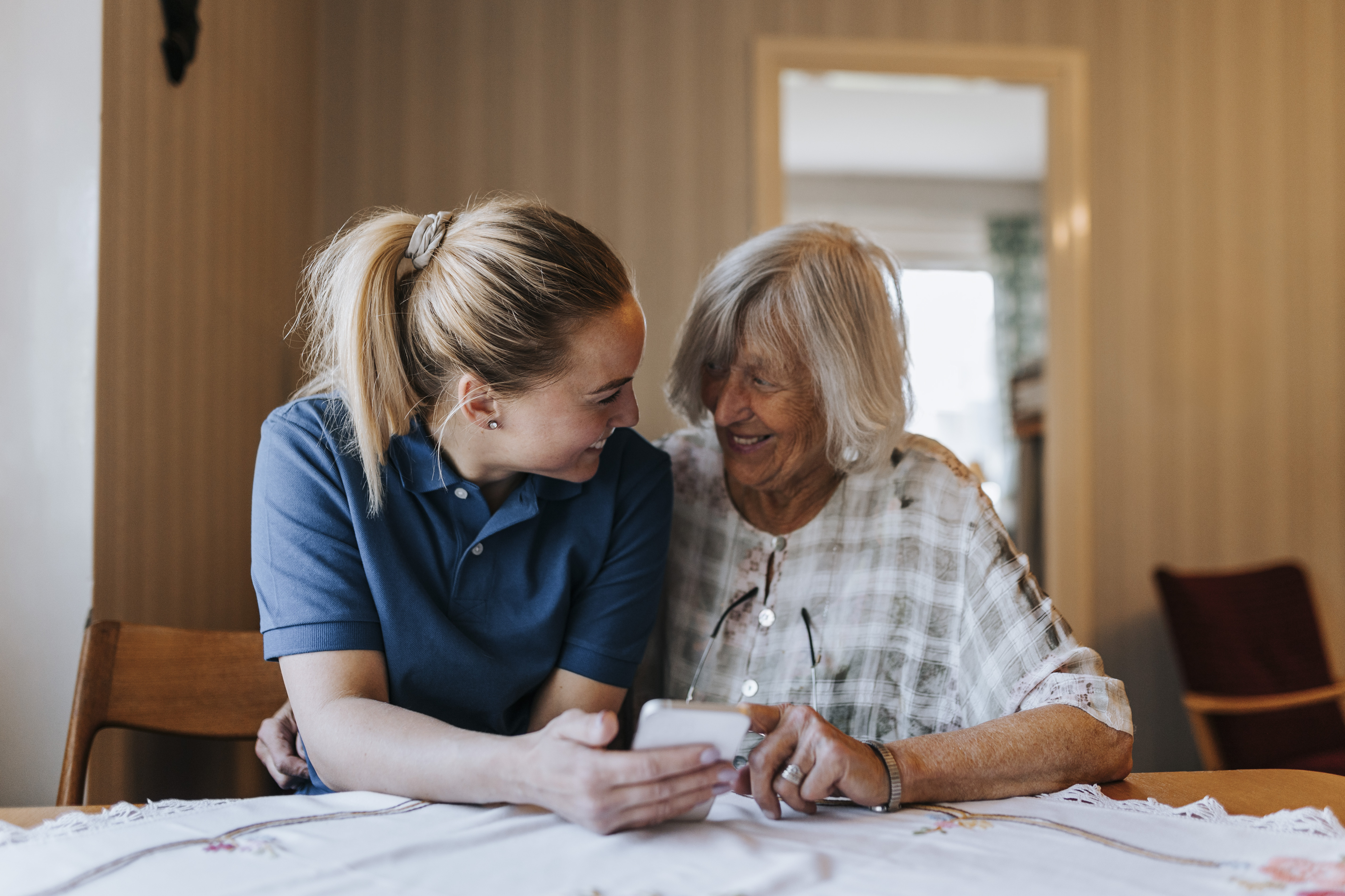 Female aged care worker helping female resident
