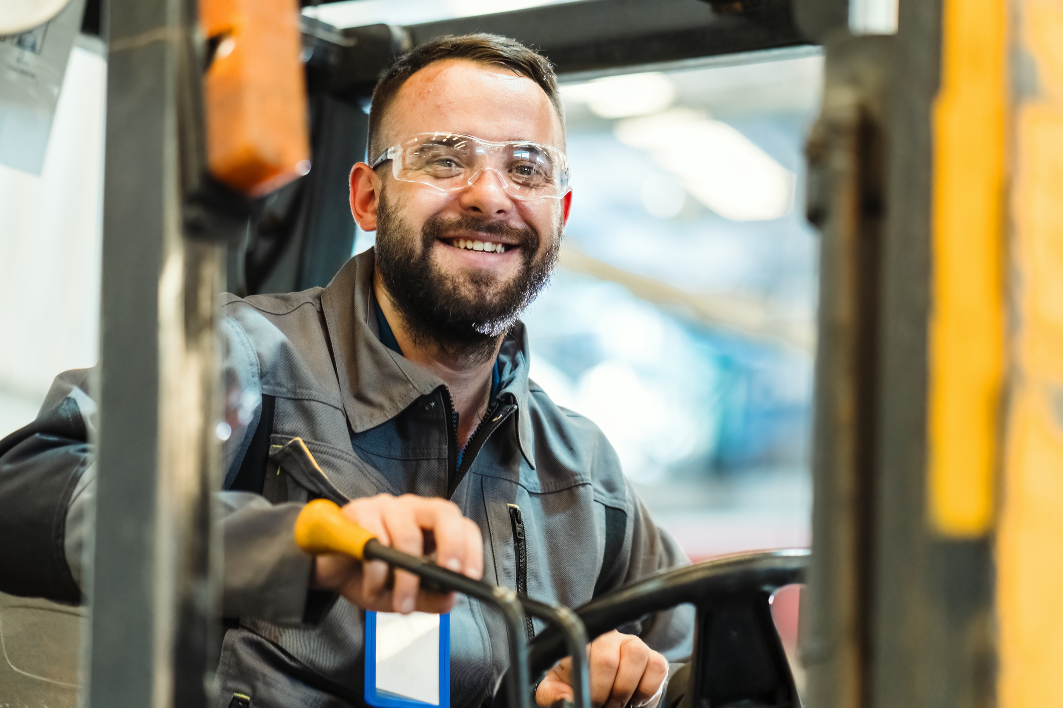 Young male smiling while driving a forklift
