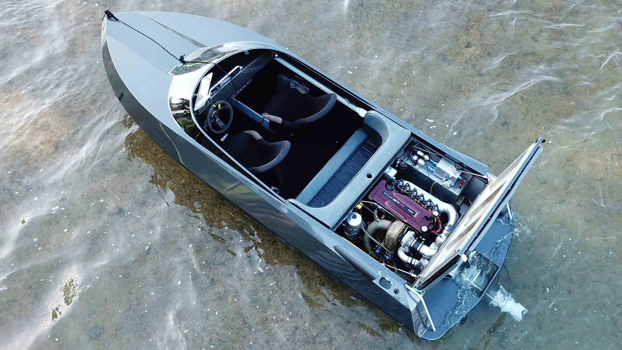 Silver jet boat floats with RB30/26 Nissan Skyline car engine exposed under the engine cover