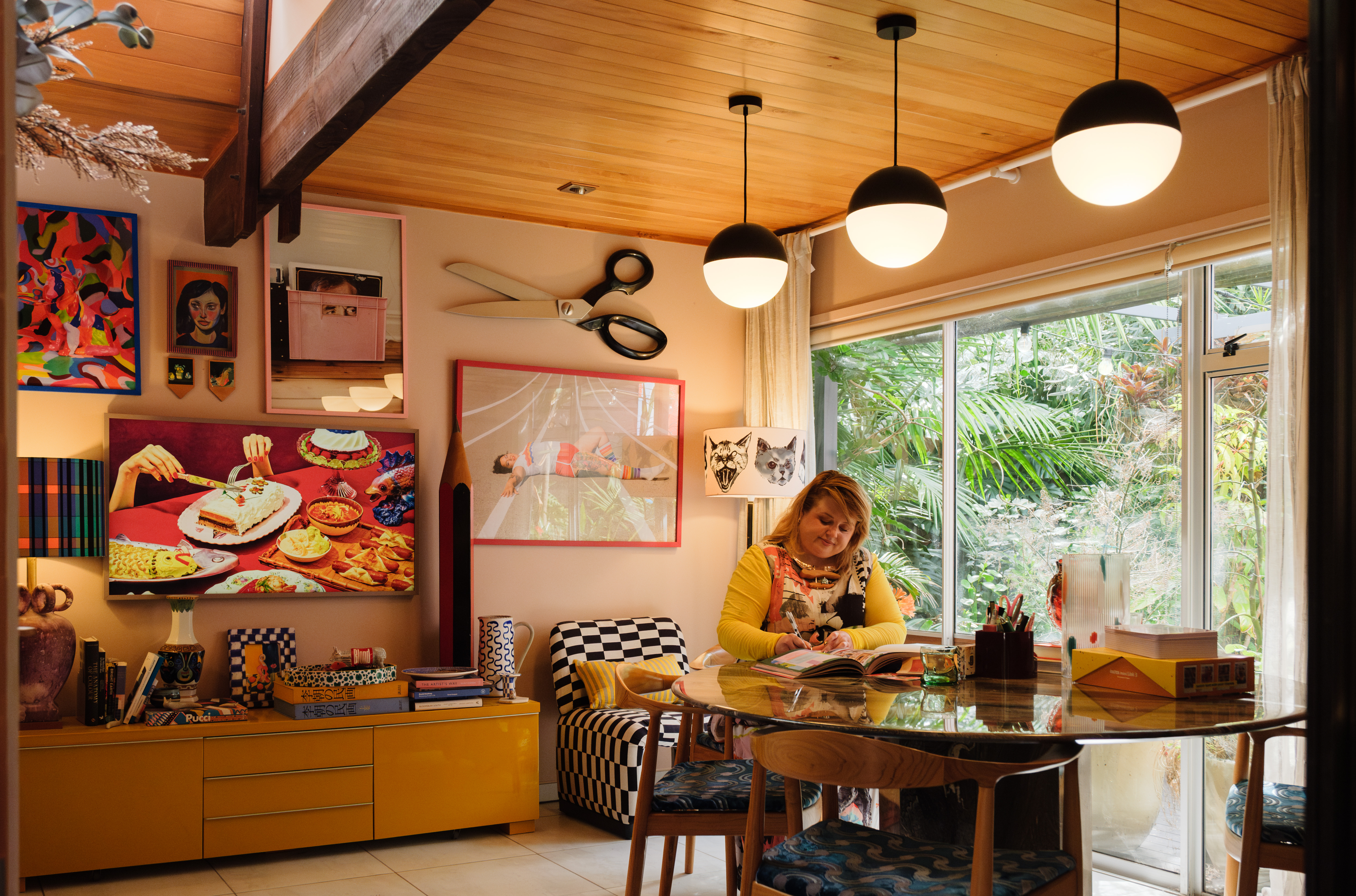 Evie reading a book at her dining room table