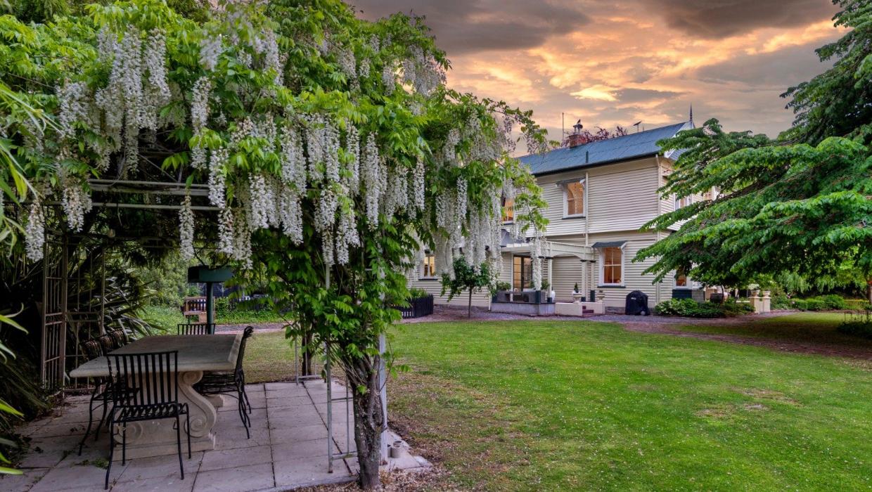 The garden features a wisteria-cloaked pergola.