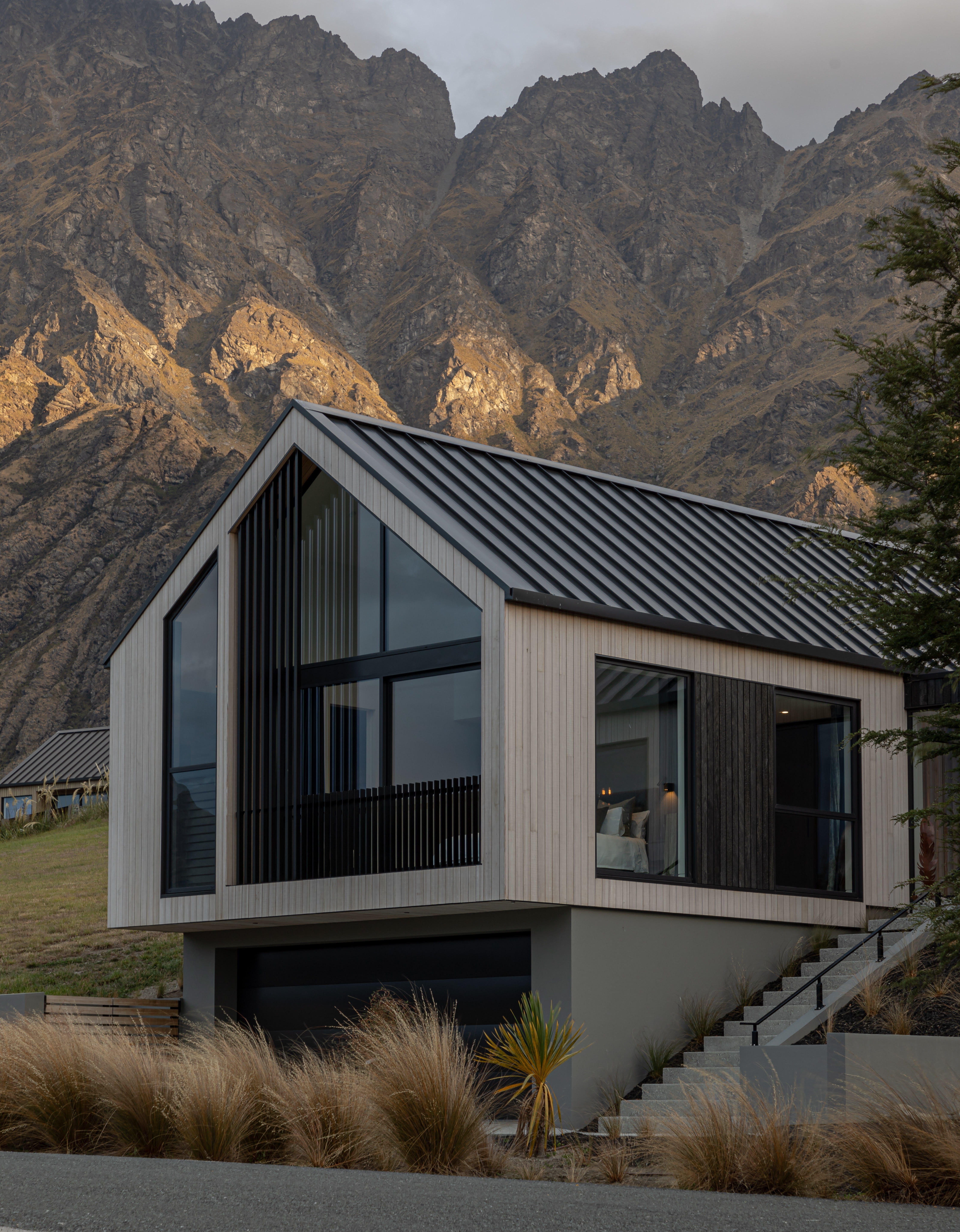 Vertical timber cladding used in this home designed by Ben Hudson Architects creates crisp lines accentuating the dramatic alpine setting. Image by John Williams. 