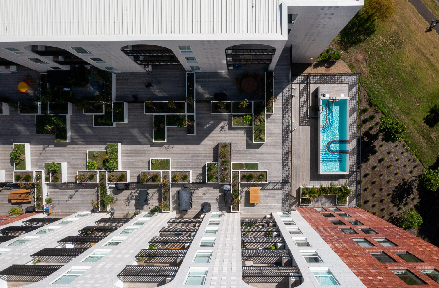 At the gateway to Avondale town centre, this building of arches and brick is a commanding presence that marks a change of face for one of West Auckland’s most populous suburbs. A rooftop garden sits between the two buildings, a pool adjacent, creating a green community space for residents.