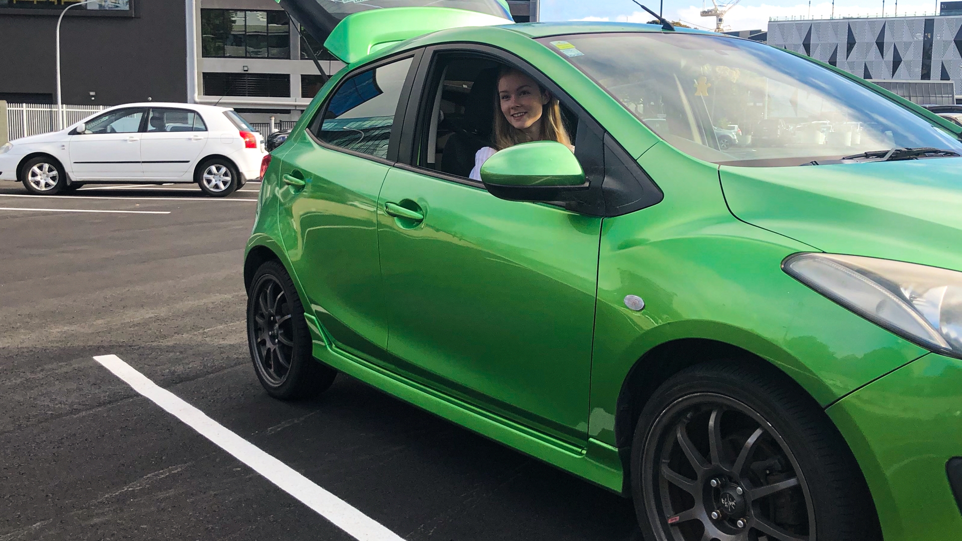 Lady behind wheel of green car
